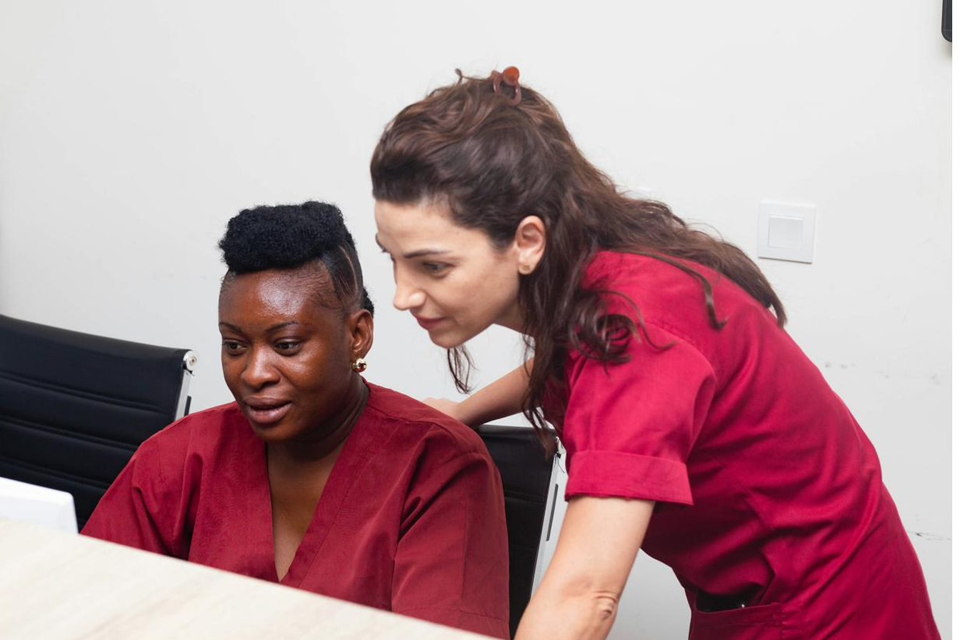 Two healthcare professionals reviewing compliance records